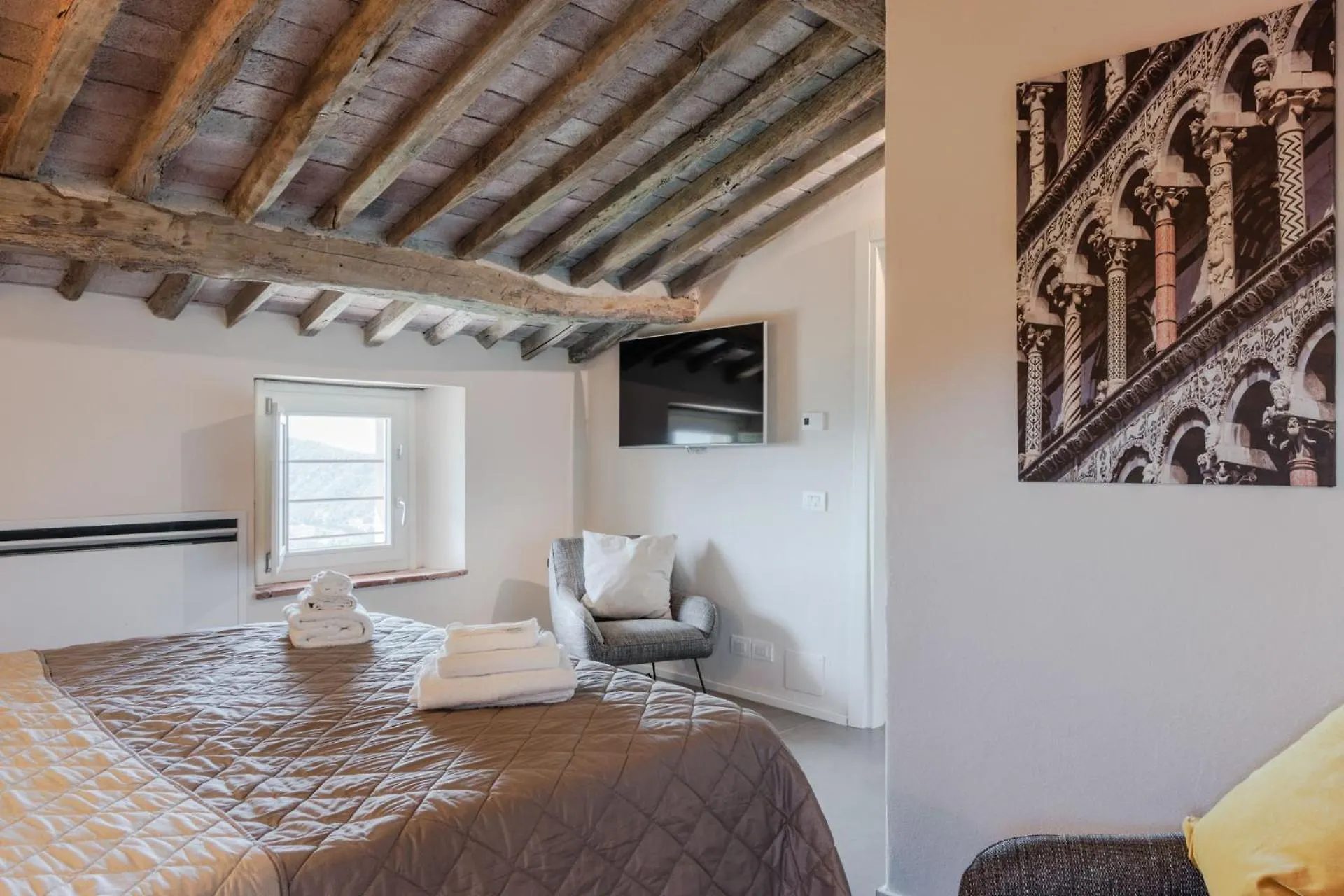 A bedroom at Villa Gioma with a king bed under the beams
