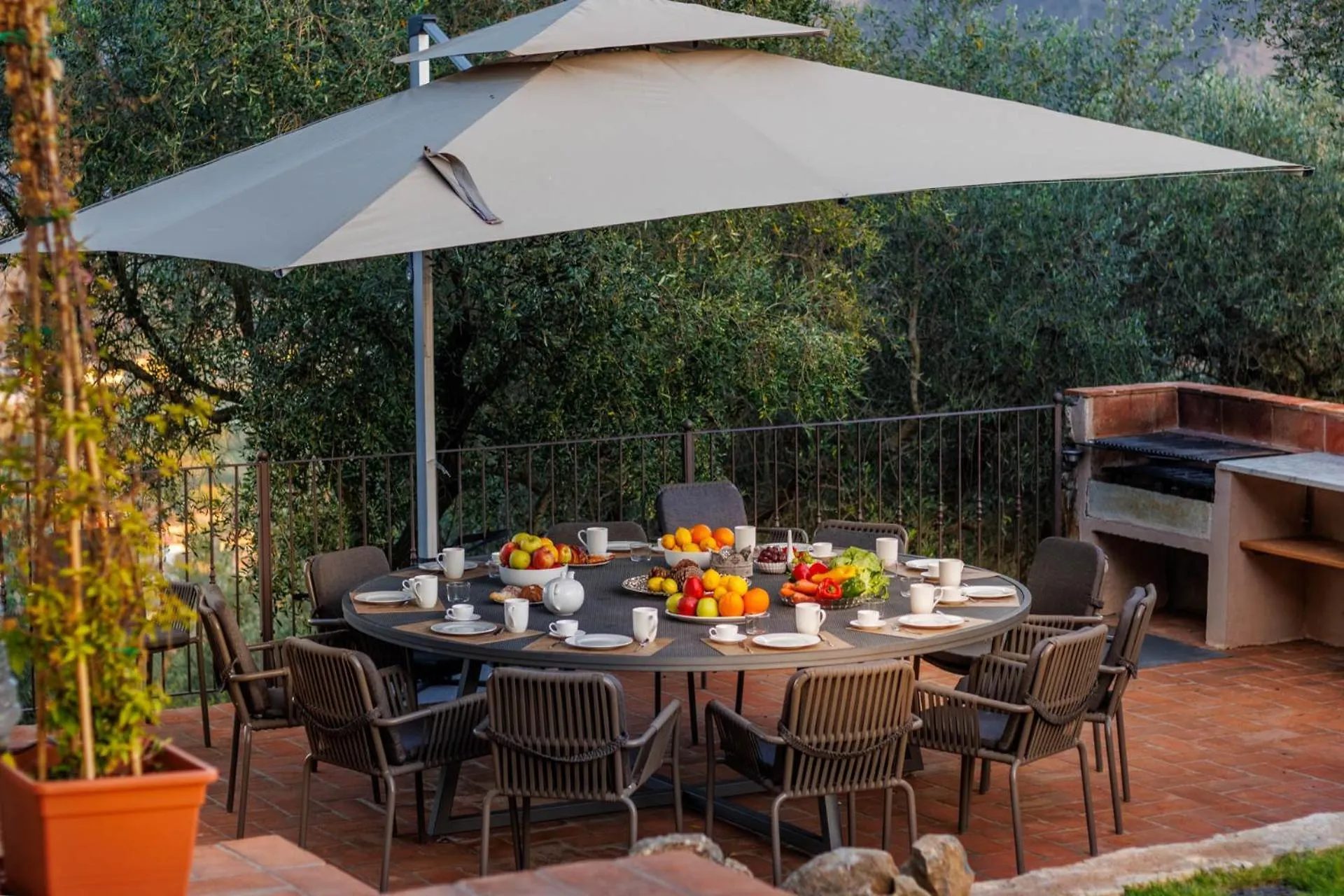 The round table under the parasol with seasonal fruit