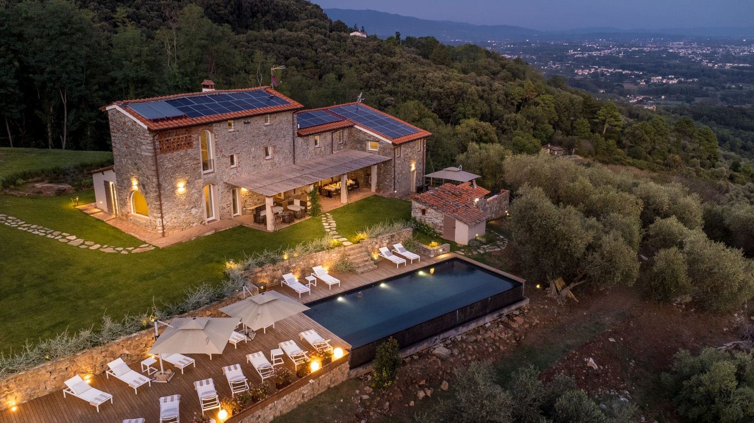 Villa Gioma from outside: the stone farmhouse and the terrace over the hills of Lucca