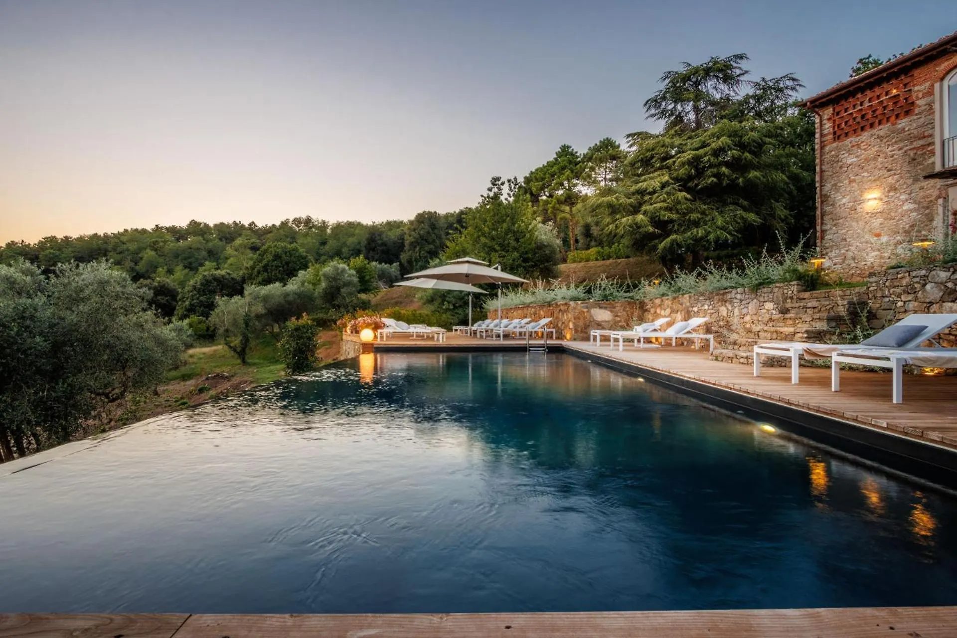 Villa Gioma from outside: the stone farmhouse and the terrace over the hills of Lucca