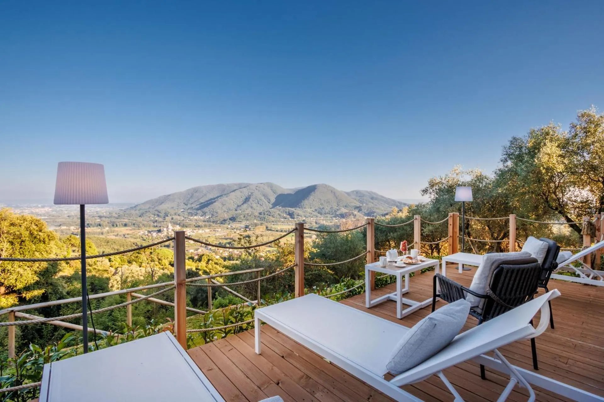 Villa Gioma from outside: the stone farmhouse and the terrace over the hills of Lucca
