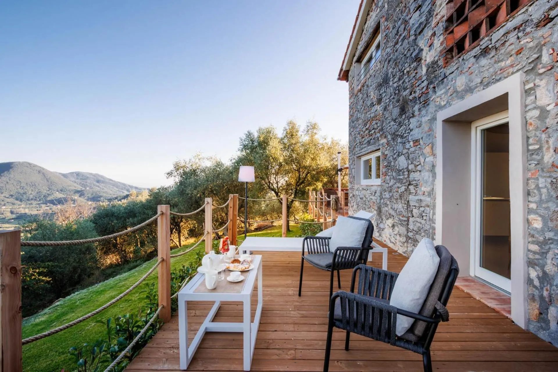 Villa Gioma from outside: the stone farmhouse and the terrace over the hills of Lucca