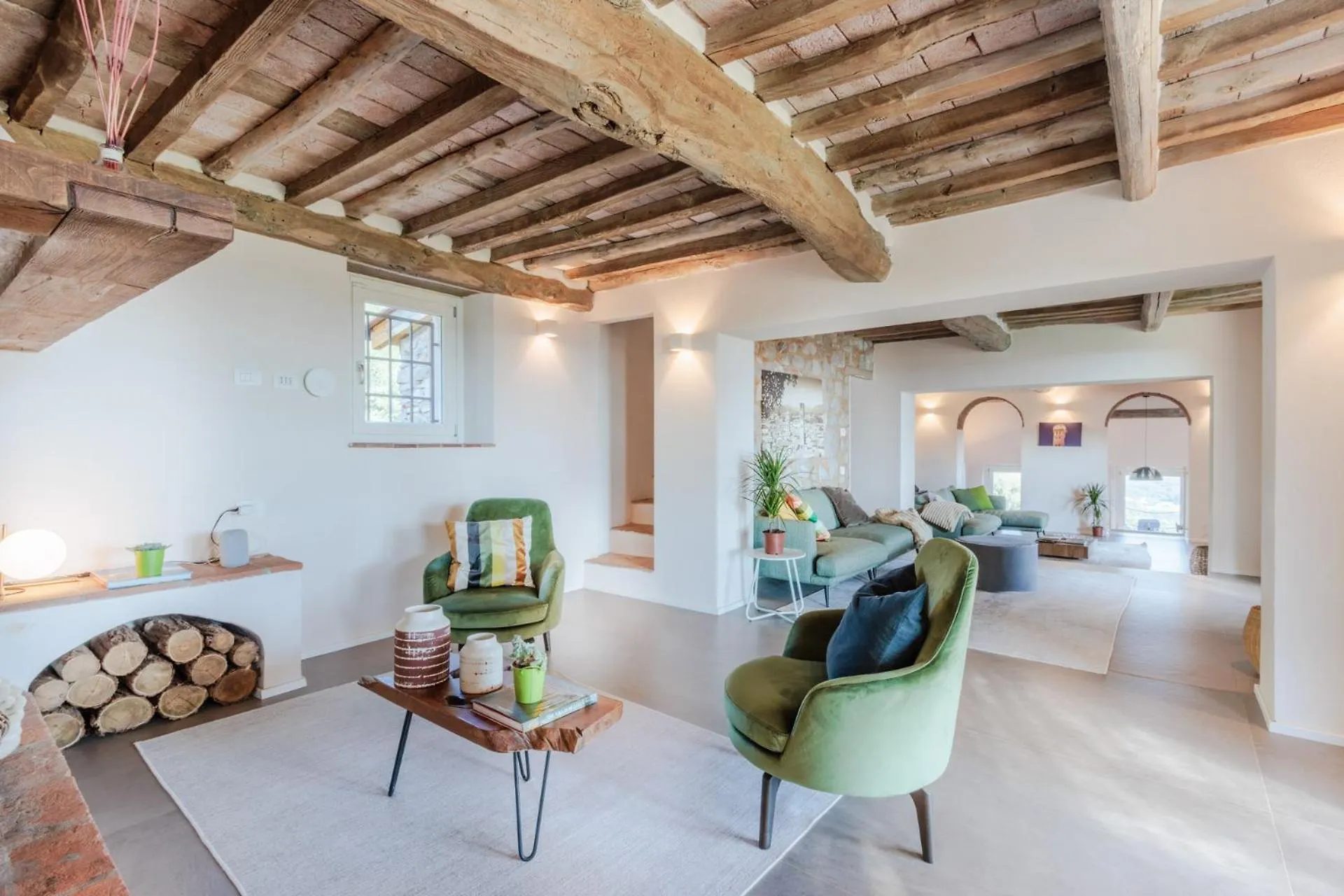 The living room at Villa Gioma with exposed beams and stone fireplace