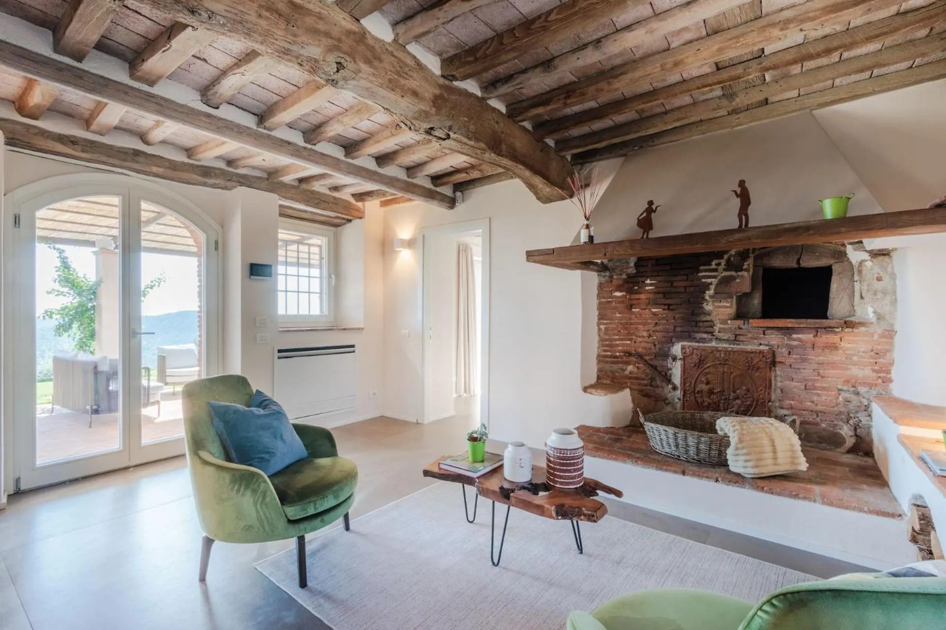 The living room at Villa Gioma with exposed beams and stone fireplace