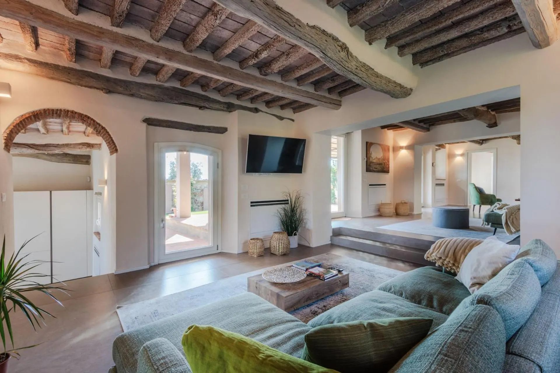 The living room at Villa Gioma with exposed beams and stone fireplace